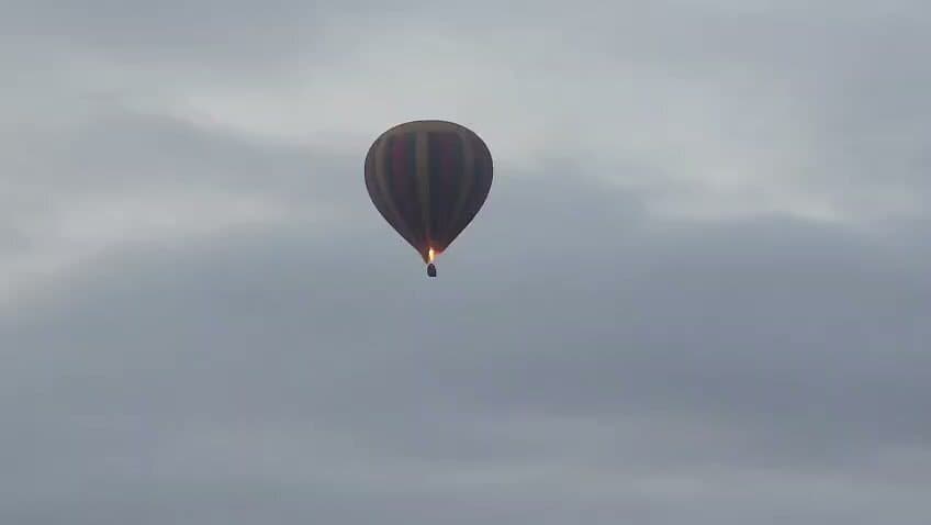 Hot-air balloon floating above a hazy plain